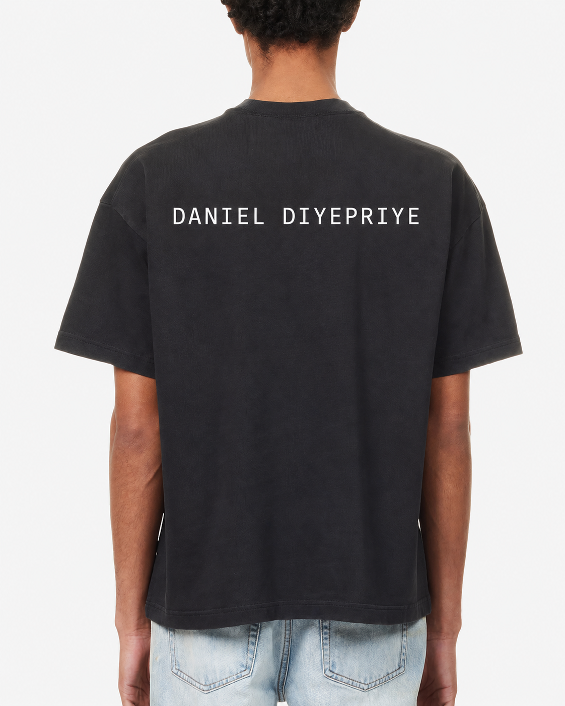 The Pigment Tee · black · back · DANIEL DIYEPRIYE wordmark