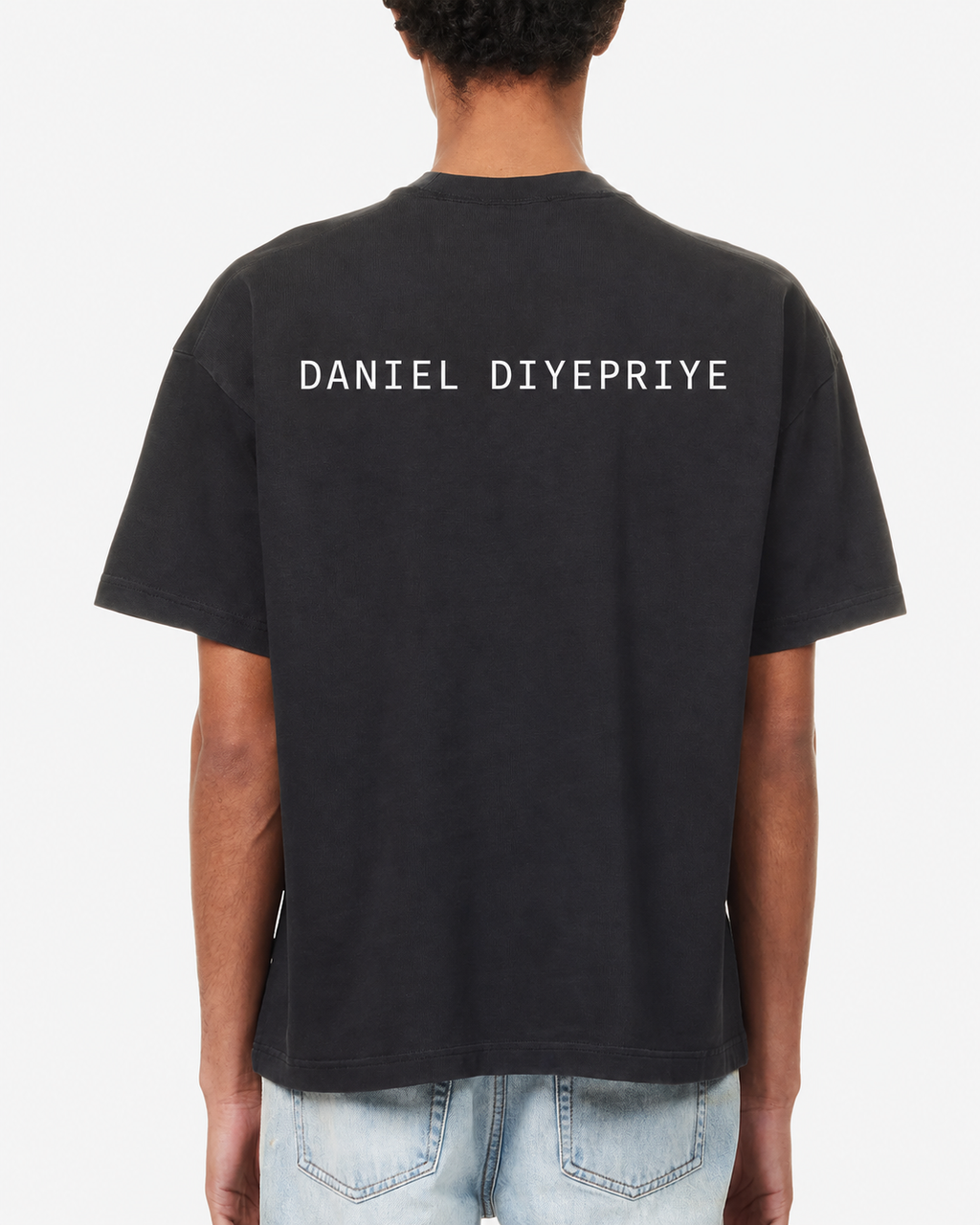 The Pigment Tee · black · back · DANIEL DIYEPRIYE wordmark
